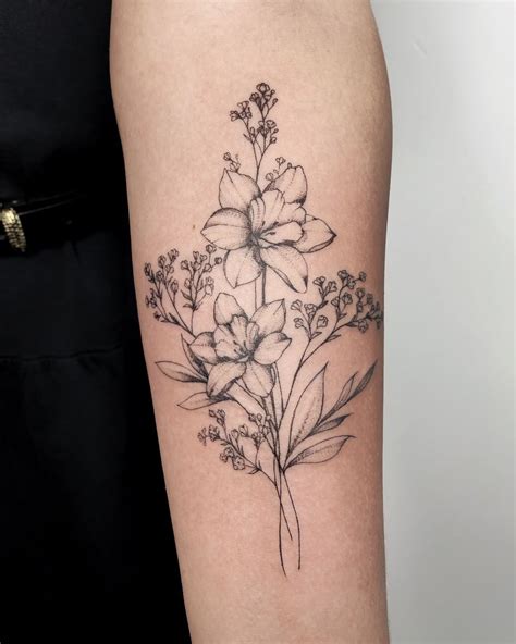 Light flowers on the inner bicep that wrap slightly from top to bottom look very elegant and beautiful. . Birth flower tattoos